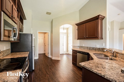 a renovated kitchen with granite counter tops and stainless steel appliances
