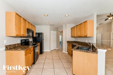 A kitchen with wooden cabinets and black appliances.