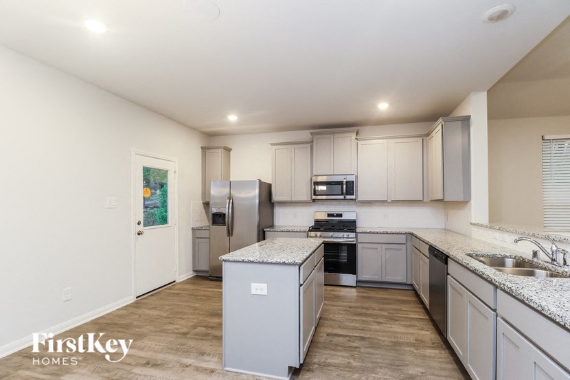 a kitchen with white cabinets and stainless steel appliances
