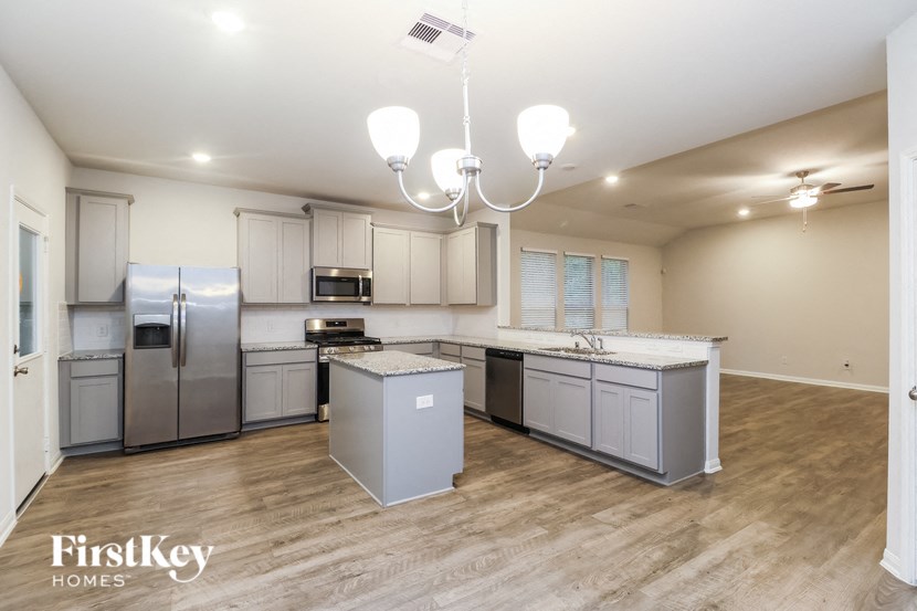 a large kitchen with stainless steel appliances and white cabinets