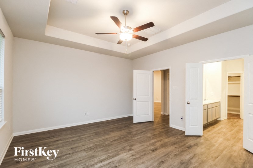 a living room with white walls and a ceiling fan