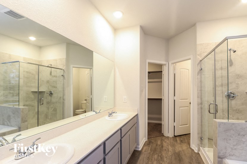 a bathroom with a large mirror and a shower and a sink