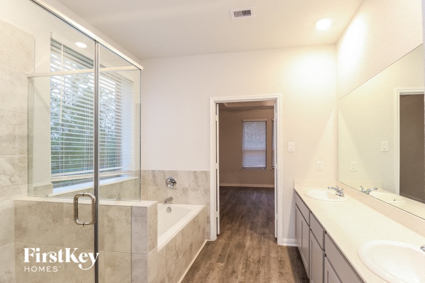 a bathroom with two sinks and a tub and a shower