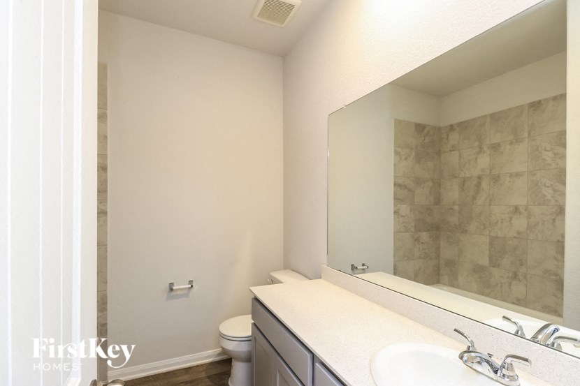 a bathroom with a large mirror and a sink and a toilet