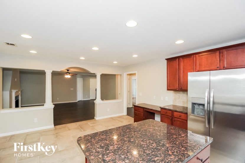 a kitchen with granite counter tops and a stainless steel refrigerator