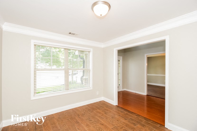 an empty living room with a large window and wooden floors