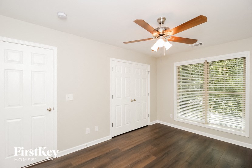 a bedroom with a ceiling fan and a door to a closet