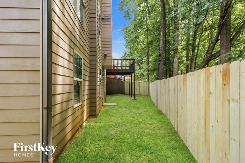 a backyard with a wooden fence and a yard with grass