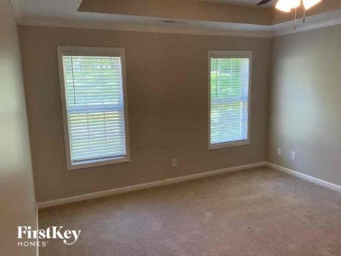 a living room with two windows and a carpet