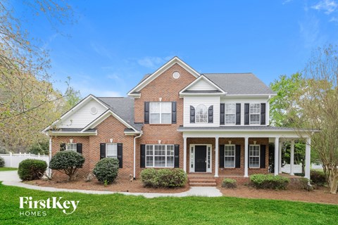 a brick house with white trim and black shutters