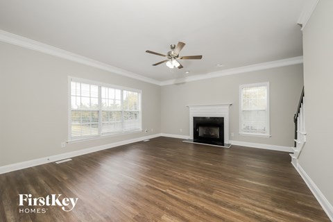 a living room with a fireplace and a ceiling fan