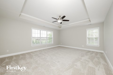 the master bedroom has a vaulted ceiling and a ceiling fan