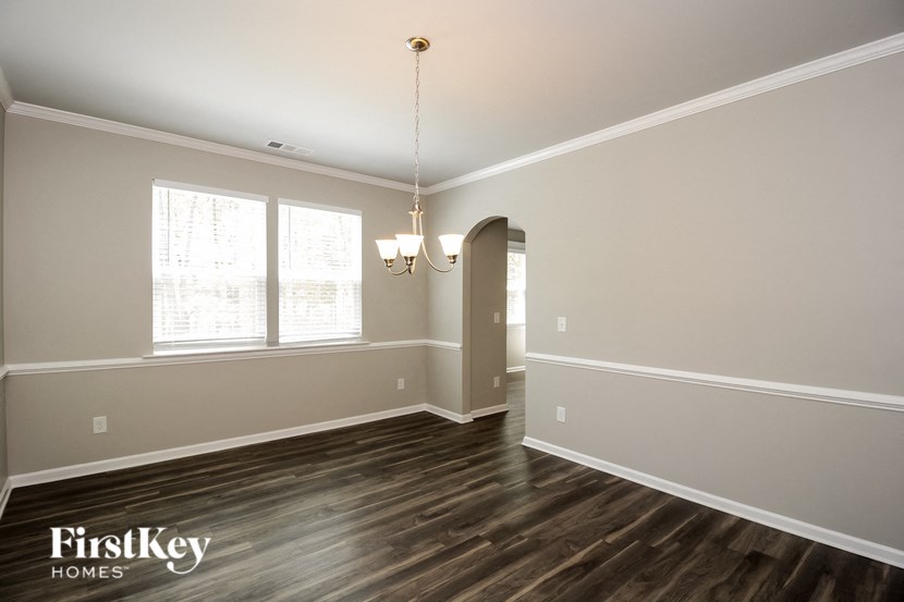A room with wooden floors and a chandelier hanging from the ceiling.