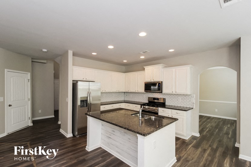 A kitchen with a granite countertop and white cabinets.
