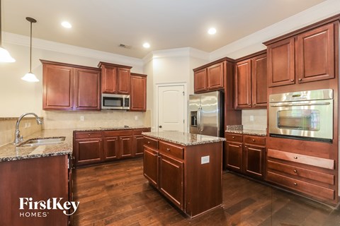 a kitchen with wooden cabinets and granite counter tops and stainless steel appliances