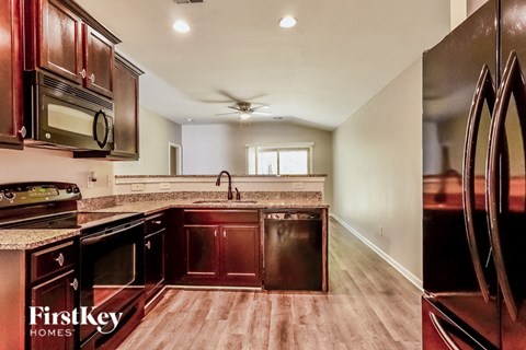 A kitchen with wooden cabinets and a black refrigerator.