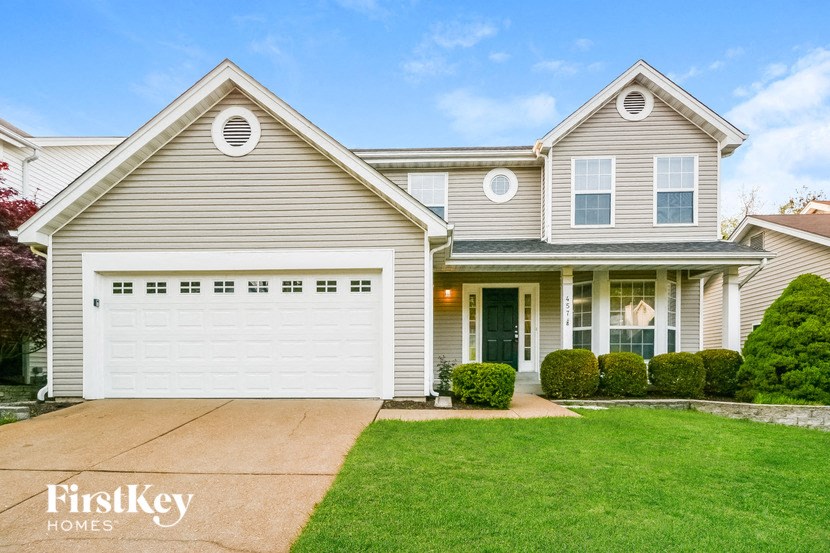 a house with a white garage door and a lawn