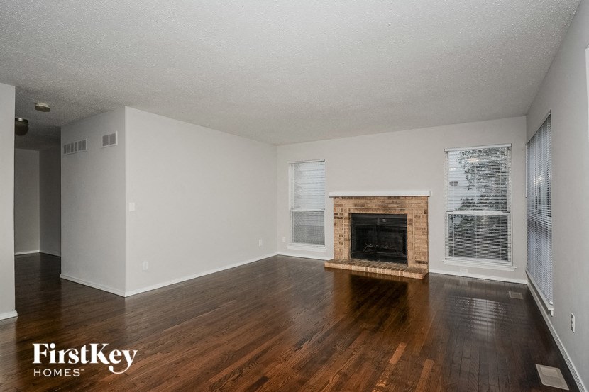a living room with wood floors and a fireplace