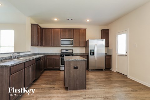 a kitchen with wooden cabinets and stainless steel appliances and a refrigerator