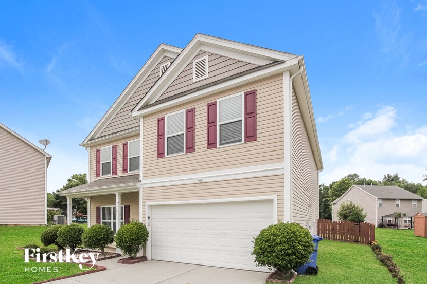 a home with a white garage door and a tan house