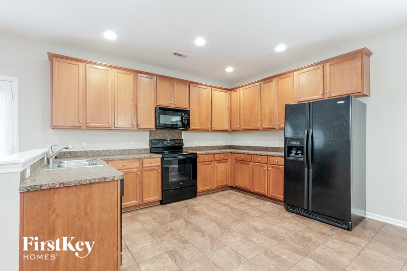 a kitchen with wooden cabinets and a black refrigerator