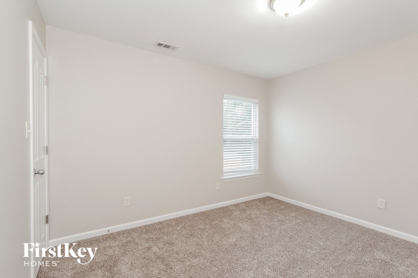 an empty room with carpet and a window
