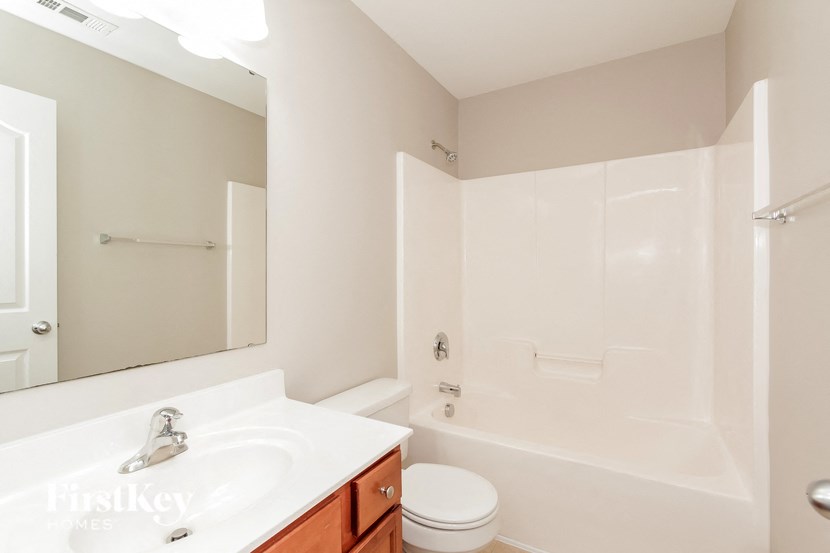 a bathroom with a sink toilet and a mirror