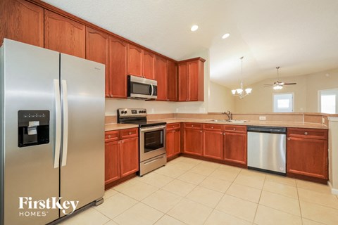 A kitchen with wooden cabinets and a stainless steel refrigerator.