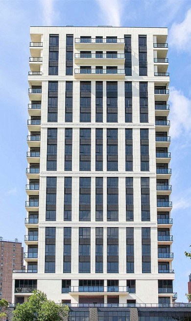 a tall building with many windows and a blue sky