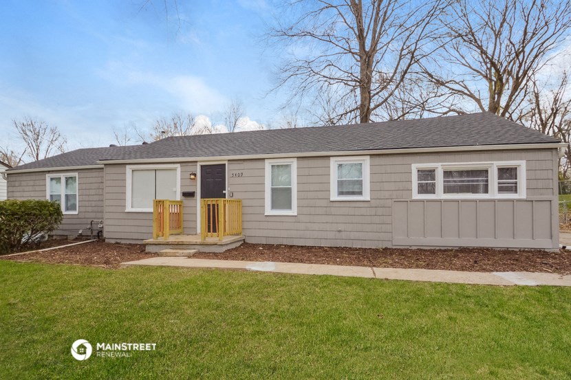 the exterior of a gray house with a front porch and a lawn