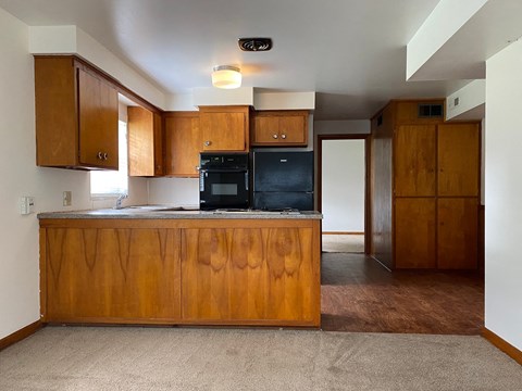 an empty kitchen with wooden cabinets and a counter