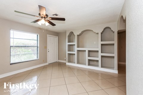a dining room with white shelves and a ceiling fan