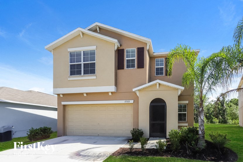 a beige house with a palm tree in front of it