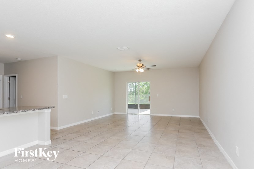 an empty living room with a ceiling fan