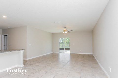 an empty living room with a ceiling fan