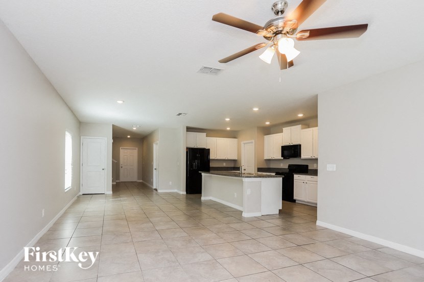 a large kitchen and living room with a ceiling fan
