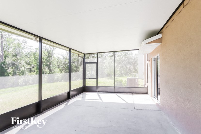 a living room with large glass windows and a concrete floor