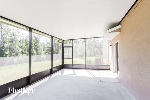 a living room with large glass windows and a concrete floor