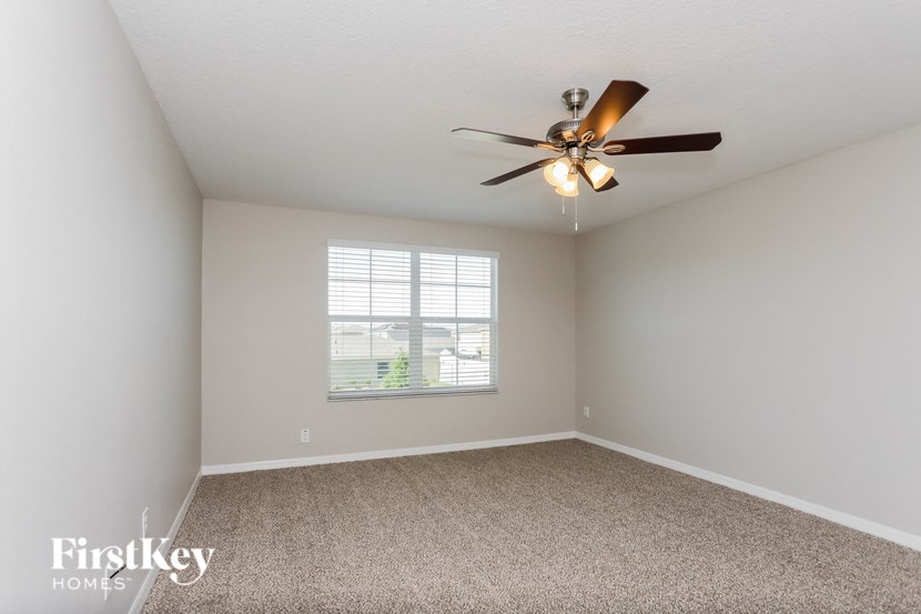 a bedroom with a ceiling fan and a window