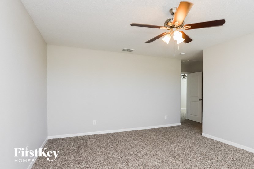 a living room with a ceiling fan and a white wall