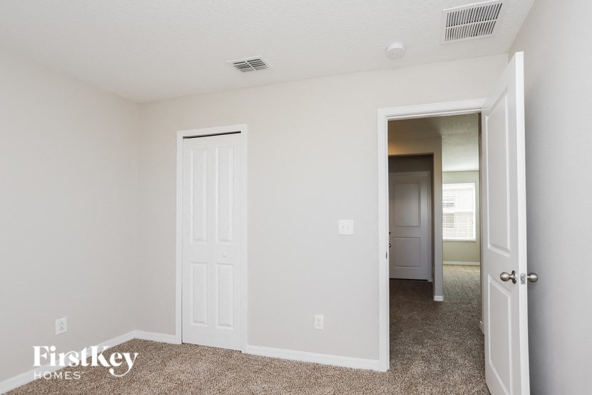 a bedroom with a closet and a door to a hallway