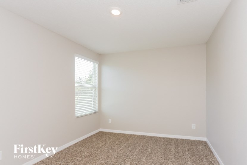 an empty room with white walls and a window