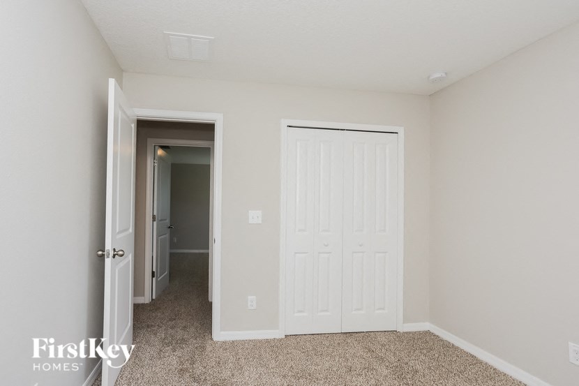 a bedroom with a closet and a door to a hallway