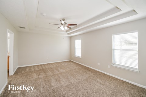 a living room with carpet and a ceiling fan