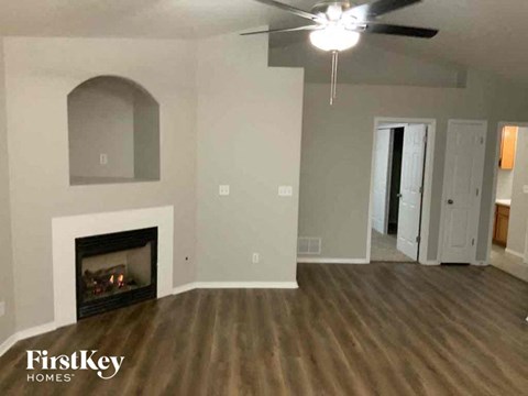 a living room with a fireplace and a ceiling fan