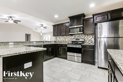 a kitchen with black cabinets and stainless steel appliances