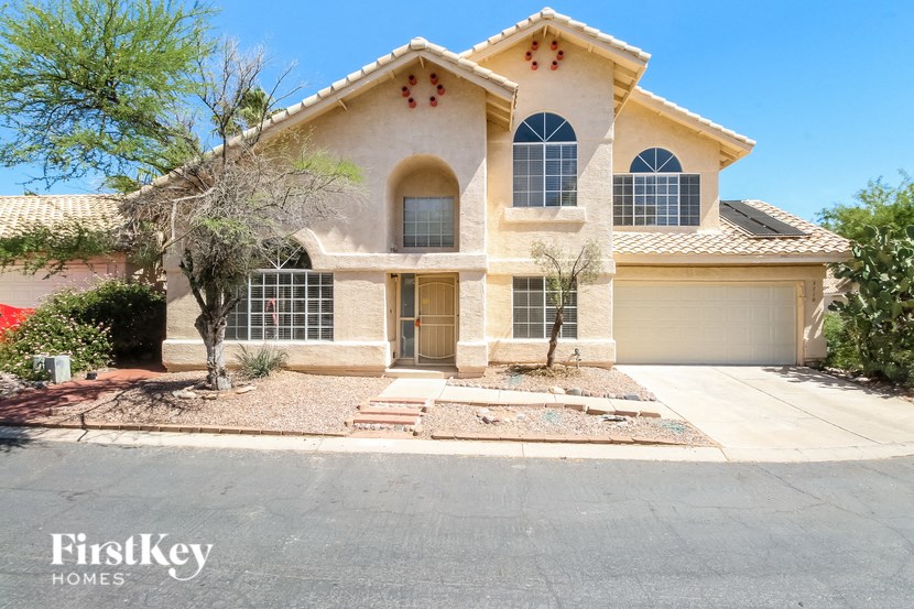 a beige house with a driveway and a garage door