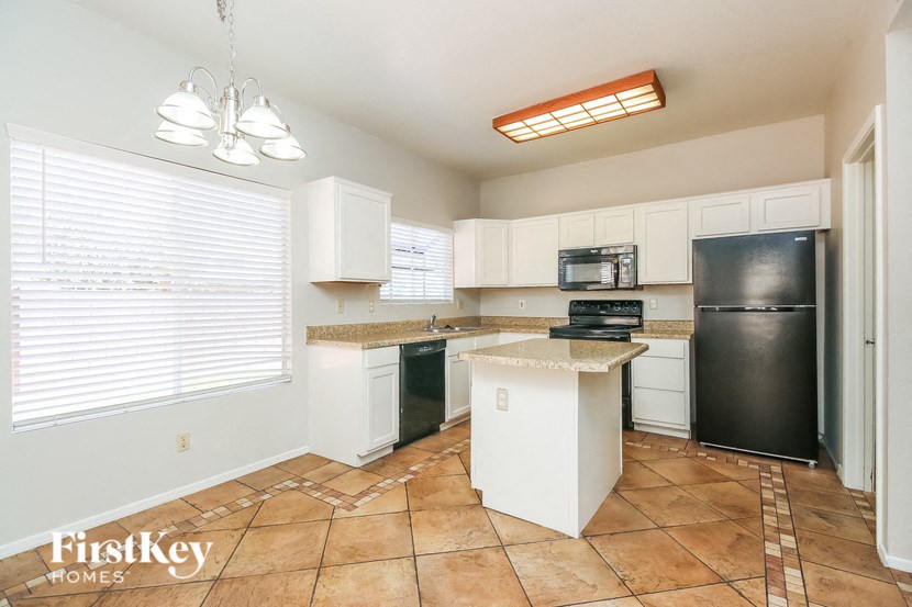 a kitchen with an island and a black refrigerator
