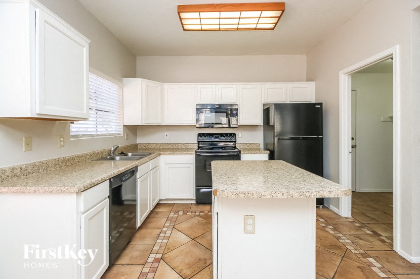 a kitchen with white cabinets and granite counter tops