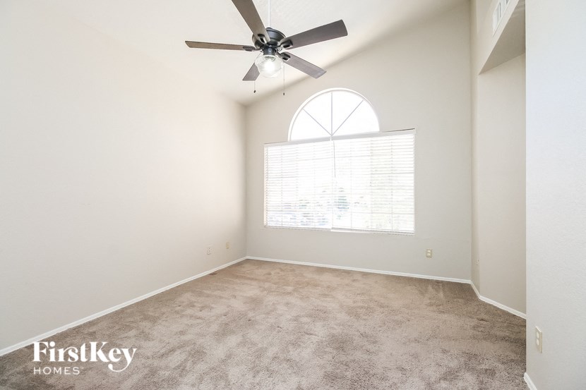 an empty room with a ceiling fan and a window